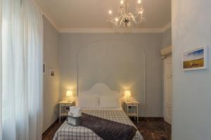 a bedroom with a bed and a chandelier at Il Giardino Del Pettirosso in Lucca