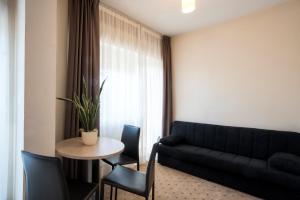 a living room with a couch and a table and chairs at Hotel Weingarten in Caldaro