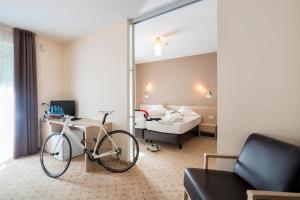 a bike parked in a room with a bedroom at Hotel Weingarten in Caldaro