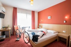 a hotel room with a bed with a bike on it at Hotel Weingarten in Caldaro