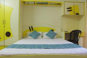 um quarto com uma cama com almofadas azuis e brancas em Rosvilla Guest House em Benaulim