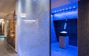 a bathroom with a shower with blue tiles at Apartment Lodge Gasserhof in Bressanone