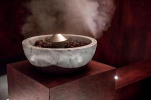 a bowl with a candle on a stand with smoke at Apartment Lodge Gasserhof in Bressanone