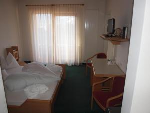 a hotel room with two beds and a table and a desk at Sporthotel Rasen in Rasùn di Sotto