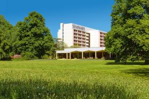 a building with a field in front of it at Seminaris Hotel Lüneburg in Lüneburg