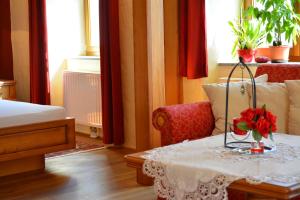 a room with a table with a vase of flowers on it at Gästehaus Turm Wachau in Weissenkirchen in der Wachau