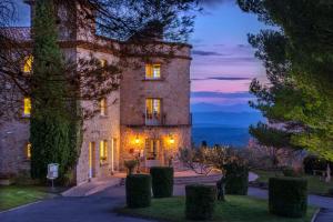 un gran edificio de piedra con luces encendidas en La Bastide De Tourtour Hotel & Spa, en Tourtour