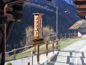 un cartel en una cerca al lado de una montaña en Affittacamere Buenavista Guest House, en Champoluc