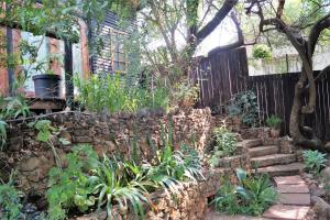 un jardin avec un mur et un escalier en pierre dans l'établissement Westmoreland Lodge, à Johannesbourg