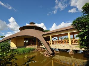 un bâtiment avec un pont sur une masse d'eau dans l'établissement Kilima Safari Camp, à Amboseli