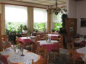 un restaurant avec tables et chaises et nappes rouges et blanches dans l'établissement Landhaus Eickhof, à Niederhaverbeck