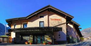 a building with a sign on the front of it at Hotel Les Saisons in Saint Vincent