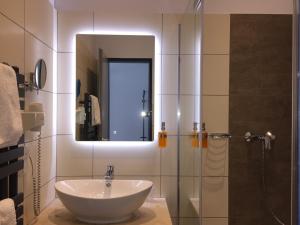 bagno con lavandino e doccia con specchio di Median Hotel Garni a Wernigerode