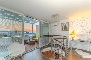 uma sala de estar com uma grande janela e uma escada em espiral em Sunset Penthouse Apartment with Jacuzzi and Seaview em Zadar