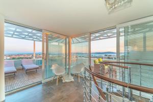 um quarto com uma varanda com uma mesa e cadeiras em Sunset Penthouse Apartment with Jacuzzi and Seaview em Zadar