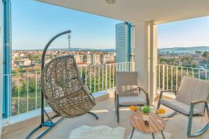 uma varanda com 2 cadeiras e uma mesa em Sunset Penthouse Apartment with Jacuzzi and Seaview em Zadar