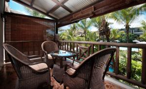 a patio with chairs and a table on a balcony at Le Palmiste Resort & Spa in Trou aux Biches