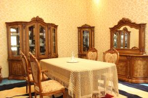 uma sala de jantar com mesa, cadeiras e espelhos em Green House Hostel em Dushanbe