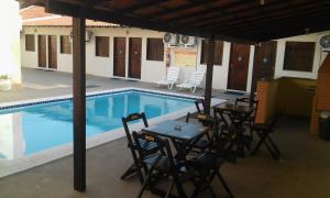 - une piscine avec des tables et des chaises à côté d'une table dans l'établissement Hotel Sambaquis, à São Luís