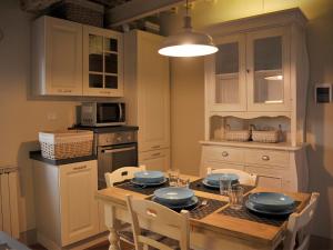 a kitchen with a wooden table with chairs and a tableasteryasteryasteryasteryastery at Appartamento il Battistero in Pistoia