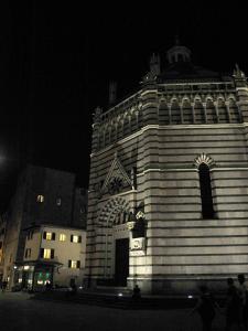 a tall building with a clock on it at night at Appartamento il Battistero in Pistoia