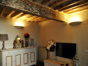 a living room with wooden ceilings and a flat screen tv at Appartamento il Battistero in Pistoia