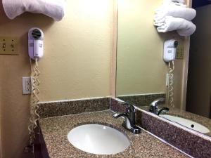 bagno con lavandino, telefono e specchio di Crown Inn Grand Prairie a Grand Prairie