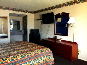 una camera d'albergo con letto e specchio di Crown Inn Grand Prairie a Grand Prairie