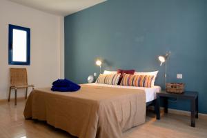 een slaapkamer met een groot bed met een blauwe muur bij Top Charco San Gines Stunning View Lanzarote By PVL in Arrecife