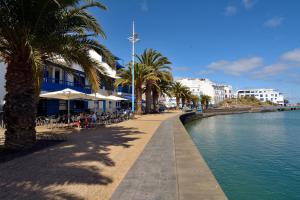 een straat met palmbomen naast een waterlichaam bij Top Charco San Gines Stunning View Lanzarote By PVL in Arrecife