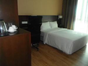 a hotel room with a bed and a desk at Keoja Hotel in Kuala Belait