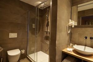 a bathroom with a shower and a toilet and a sink at Hotel De Zoete Inval Haarlemmerliede in Haarlem