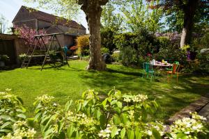 un giardino con tavolo e albero di Le Clos de l'Abbaye a Cluny