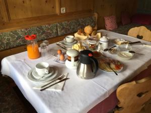 a table with a white table cloth with food on it at Fallerhof in Villnoss