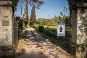 un chemin de terre avec une clôture et un panneau dans l'établissement Visconte Apartment, à Florence