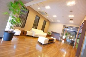 a lobby with white furniture and a potted plant at FLEXSTAY INN Ekoda in Tokyo