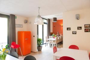 a living room and dining room with an orange refrigerator at Hotel Ladeuze in Leuven