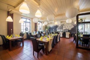 a dining room with tables and chairs and lights at Leipziger Hof in Fulda