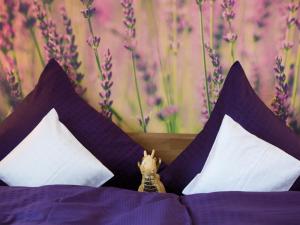 a stuffed animal is sitting on a bed with pillows at Ruster Drachennest in Rust