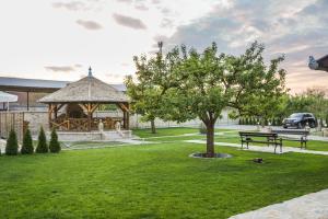 einen Park mit einem Pavillon, einer Bank und einem Baum in der Unterkunft Amfora in Palić