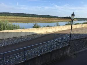 a bridge with a street light next to a river at Maaszicht in Maasmechelen