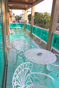 een patio met tafels en stoelen op een balkon bij Pousada Águas do Forte in Cabo Frio