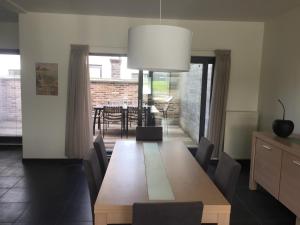 a dining room with a wooden table and chairs at Maaszicht in Maasmechelen