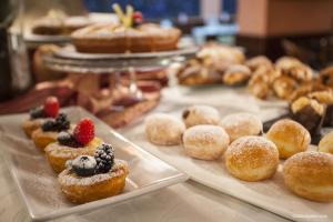 a table topped with trays of pastries with fruit on them at Hotel La Pace in Pisa