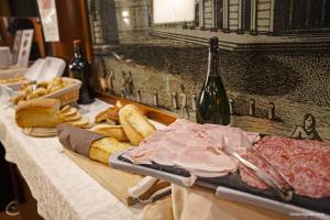 a table with meat and bread and a bottle of wine at Hotel La Pace in Pisa