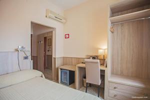 a bedroom with a bed and a desk with a chair at Hotel La Pace in Pisa