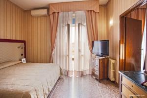 a hotel room with a bed and a television at Hotel La Pace in Pisa