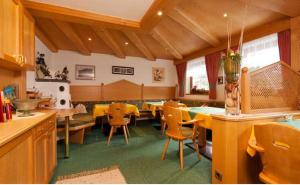 a room with tables and chairs in a restaurant at Haus Alpenglühn in Längenfeld