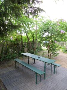 une table de pique-nique et des bancs sur une terrasse en bois dans l'établissement Fischerhaus am See, à Berlin