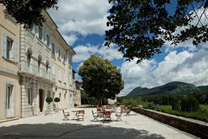 un grupo de mesas y sillas junto a un edificio en Château et Golf De Taulane, en La Martre